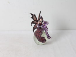 Figurine de fée au dragon sur un globe